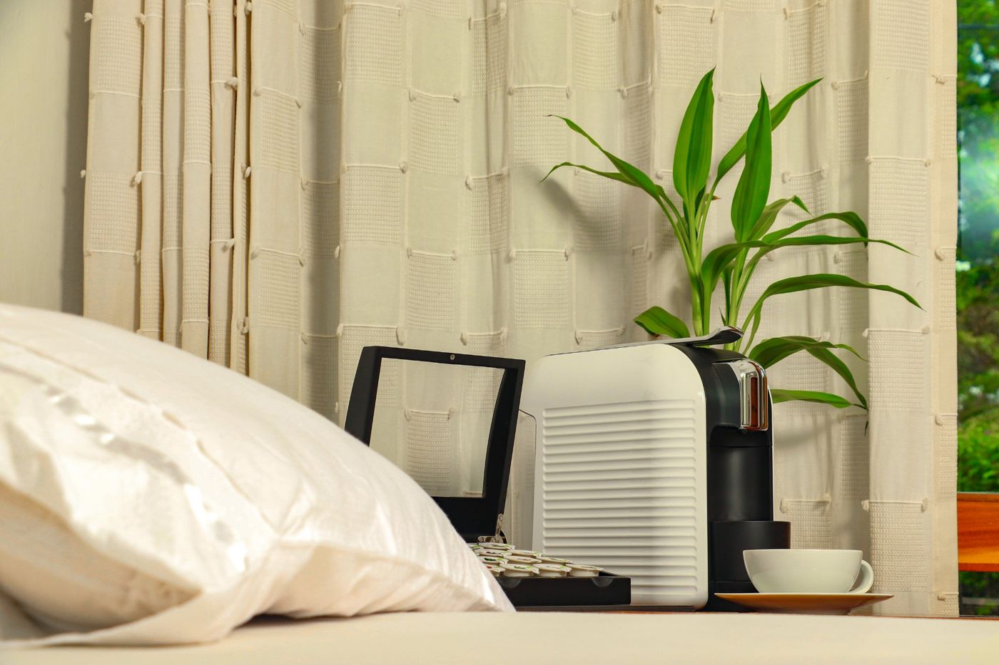 Habitación de hotel con máquina de cápsulas y caja de té